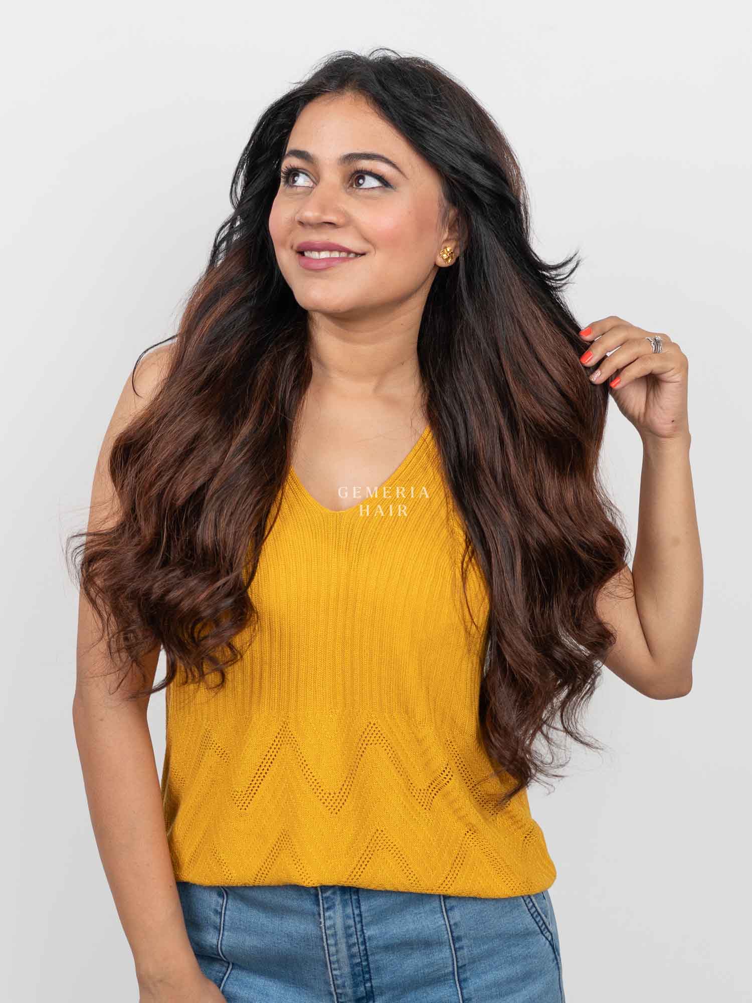 Woman styling long, wavy Barrel Brown Balayage Half Head Wig with natural-looking brown tones