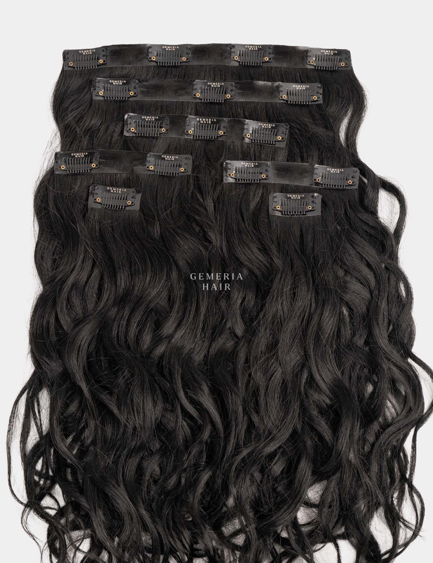 Set of black wavy hair extensions with clips on a white background