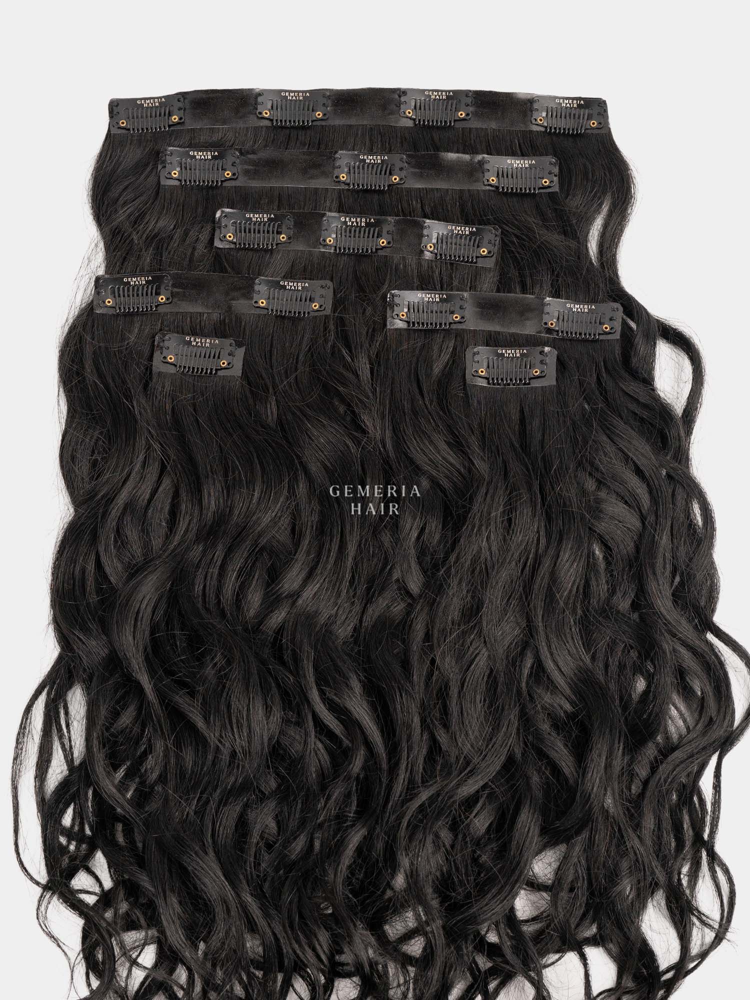 Set of black wavy hair extensions with clips on a white background
