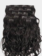 Set of black wavy hair extensions with clips on a white background